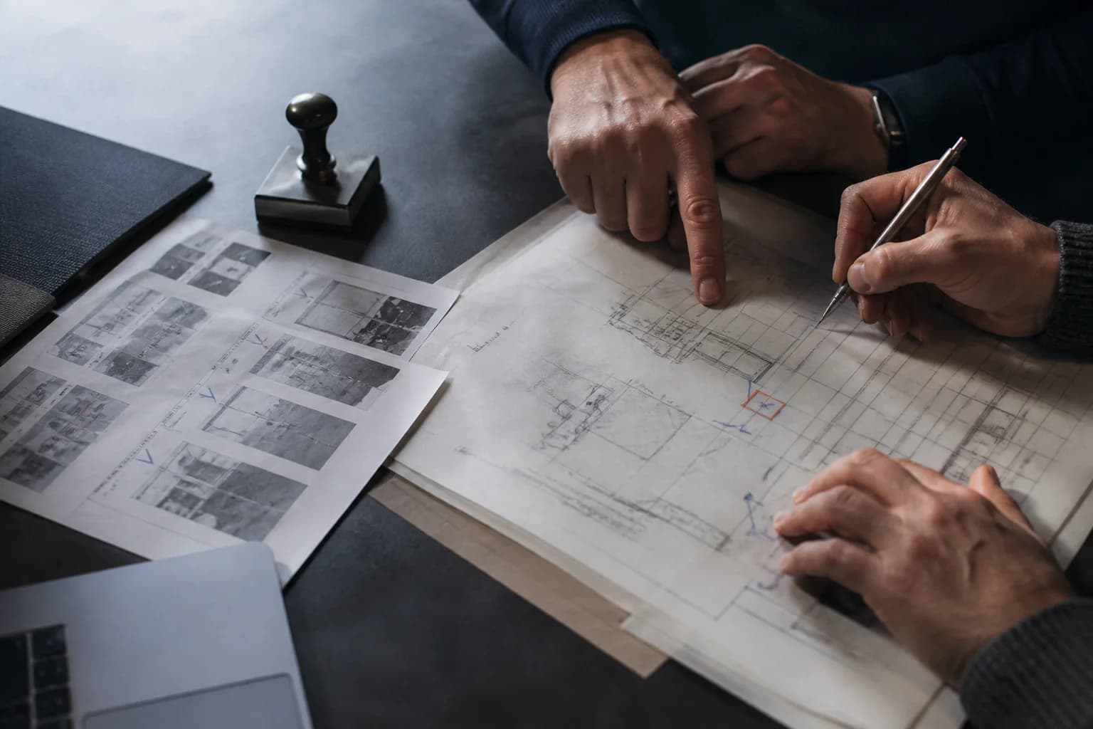 Experts reviewing and marking a technical drawing together